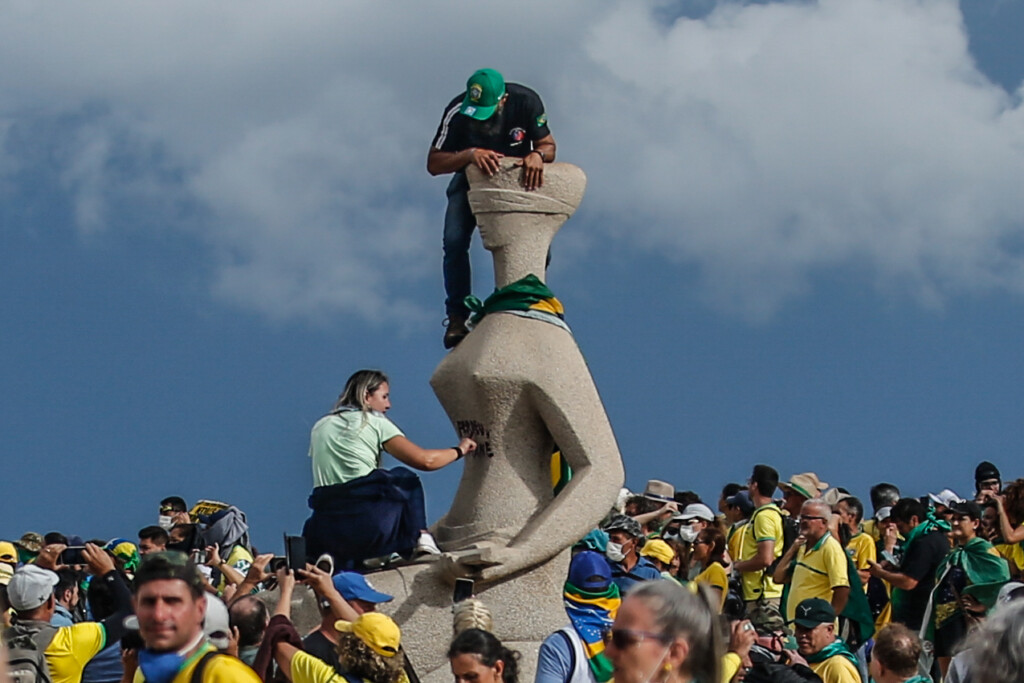 Manifestante picha a estátua da Justiça, na praça dos Três Poderes, no dia 8 de janeiro de 2023 (Foto: Gabriela Biló/Folhapress)