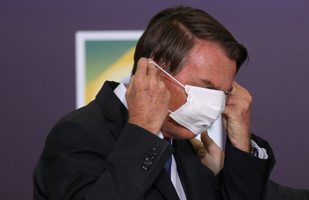 Jair Bolsonaro se atrapalha com máscara de proteção durante entrevista sobre medidas para conter a pandemia de covid-19, em março de 2020 (Foto: Pedro Ladeira/Folhapress)